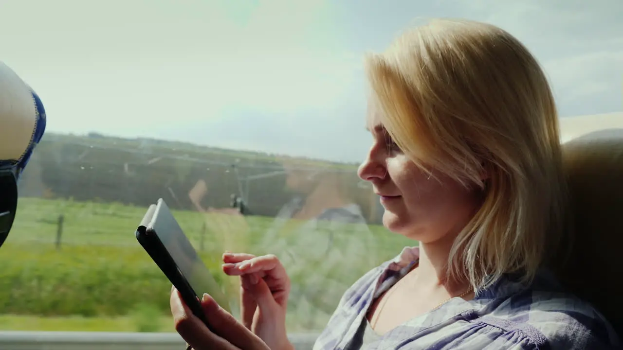 Side View Of A Young Woman Traveling By Bus And Using A Tablet