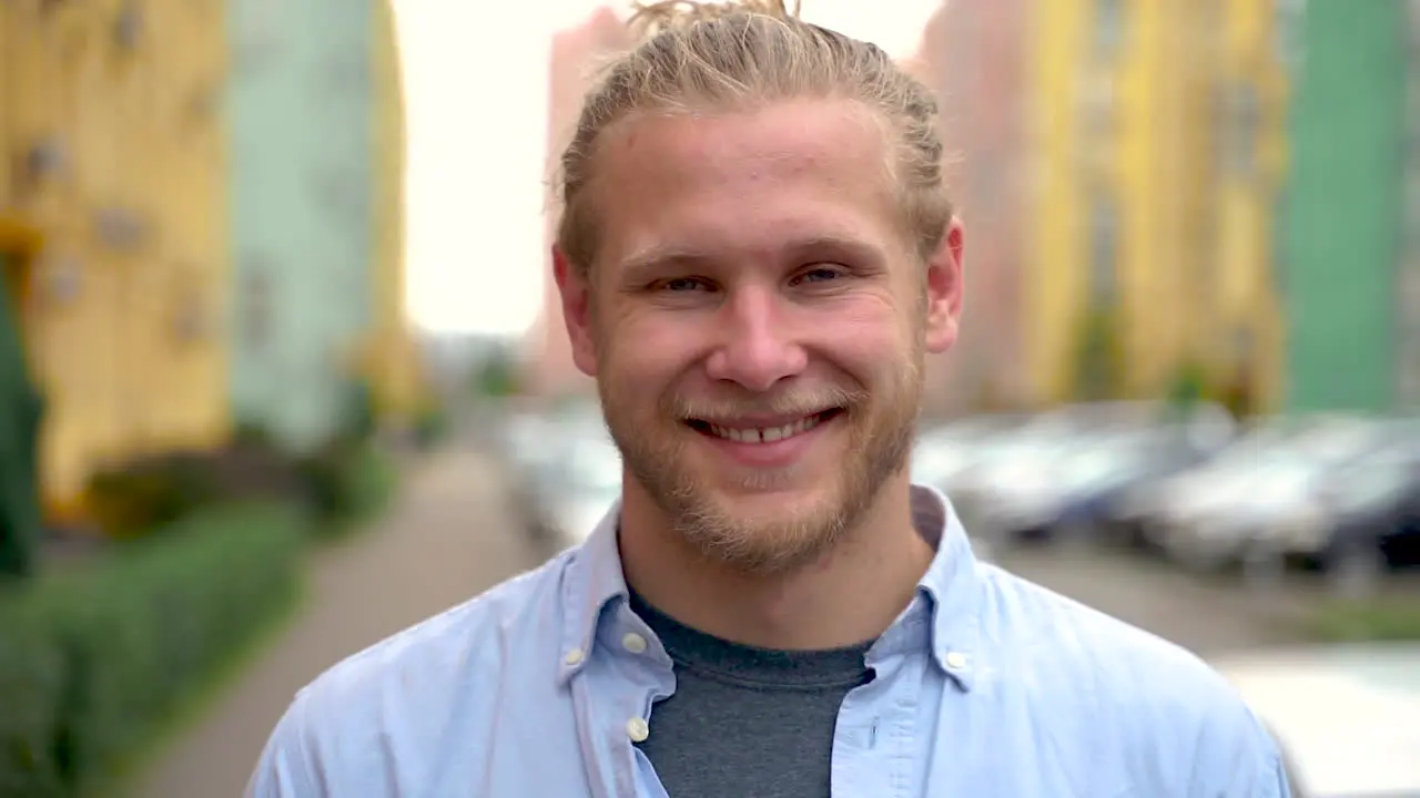 Portrait Of A Young Man Smiling And Looking At Camera Outdoors