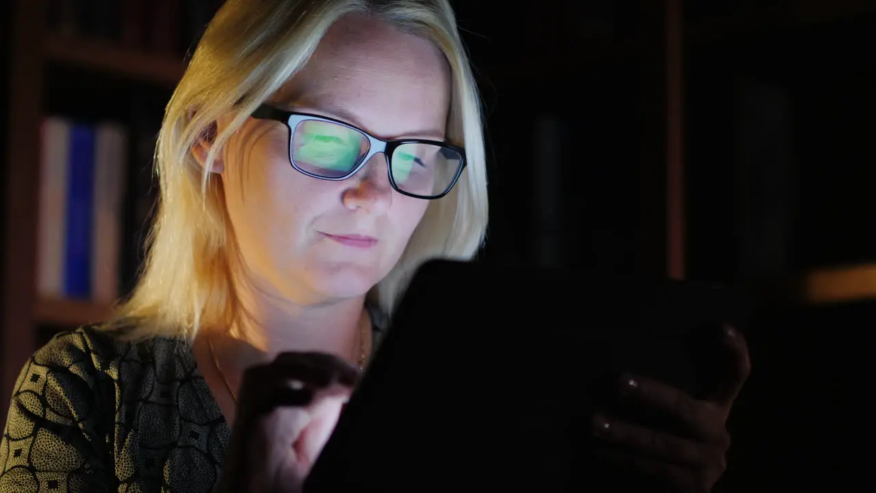 Woman in Library With Tablet at Night