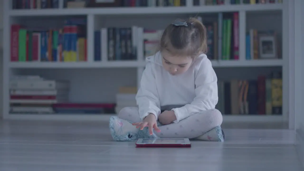 Interested girl with tablet on floor