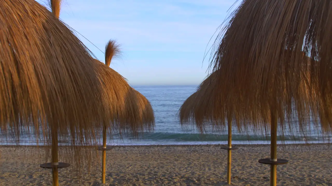 4k gimbal shot gliding through straw umbrellas on a beach in Marbella Malaga Spain costa del sol dream holiday location