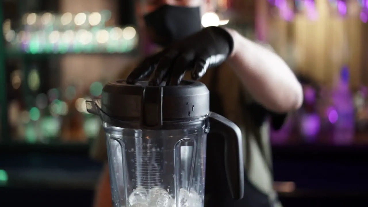 Bartender using blender with ice cubes cocktail in slow motion