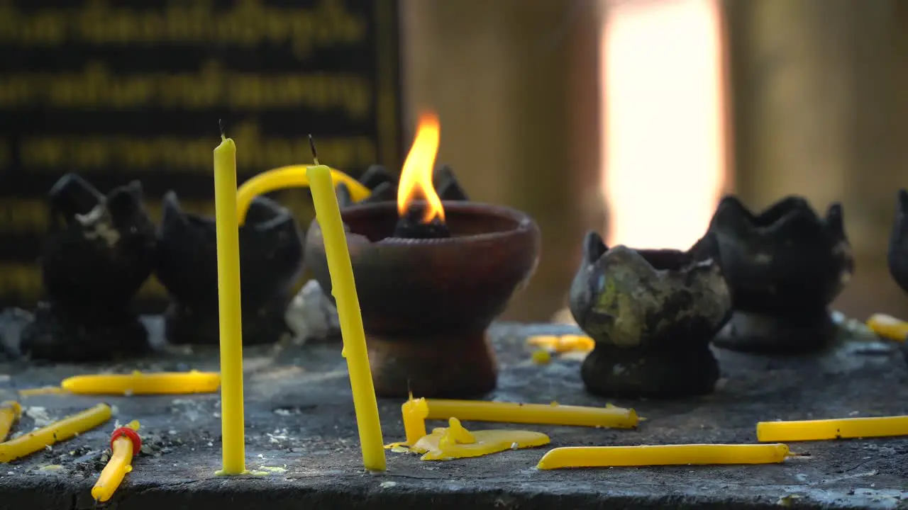 burning candles inside Phra Singh Temple in Chiang Mai Thailand