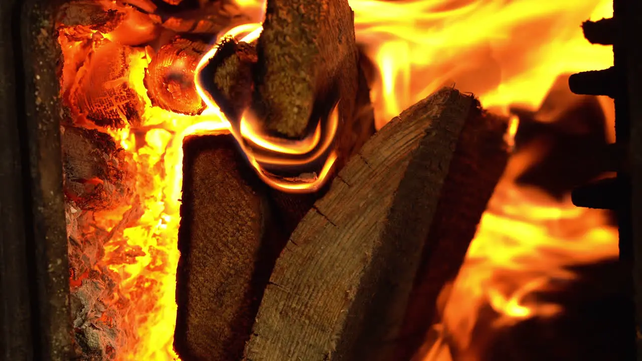 Flames and firewood burning inside the stove heating season vertical shot