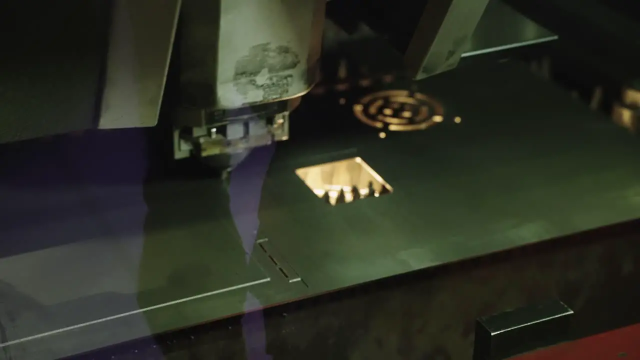 Close up automated industrial laser cutter precision cutting through thin metal