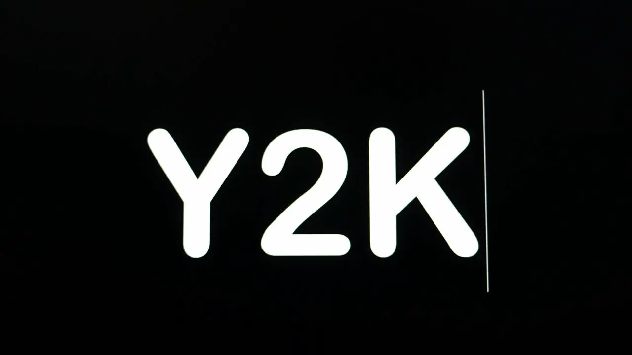 Close up of Y2K being typed into computer monitor screen with blinking cursor on black background copy space