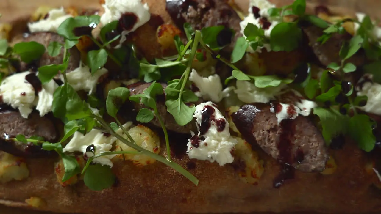 Top View of a Chef composing a pizza dripping wine reduction on top of a sausage potato and mozzarella Roman style pizza