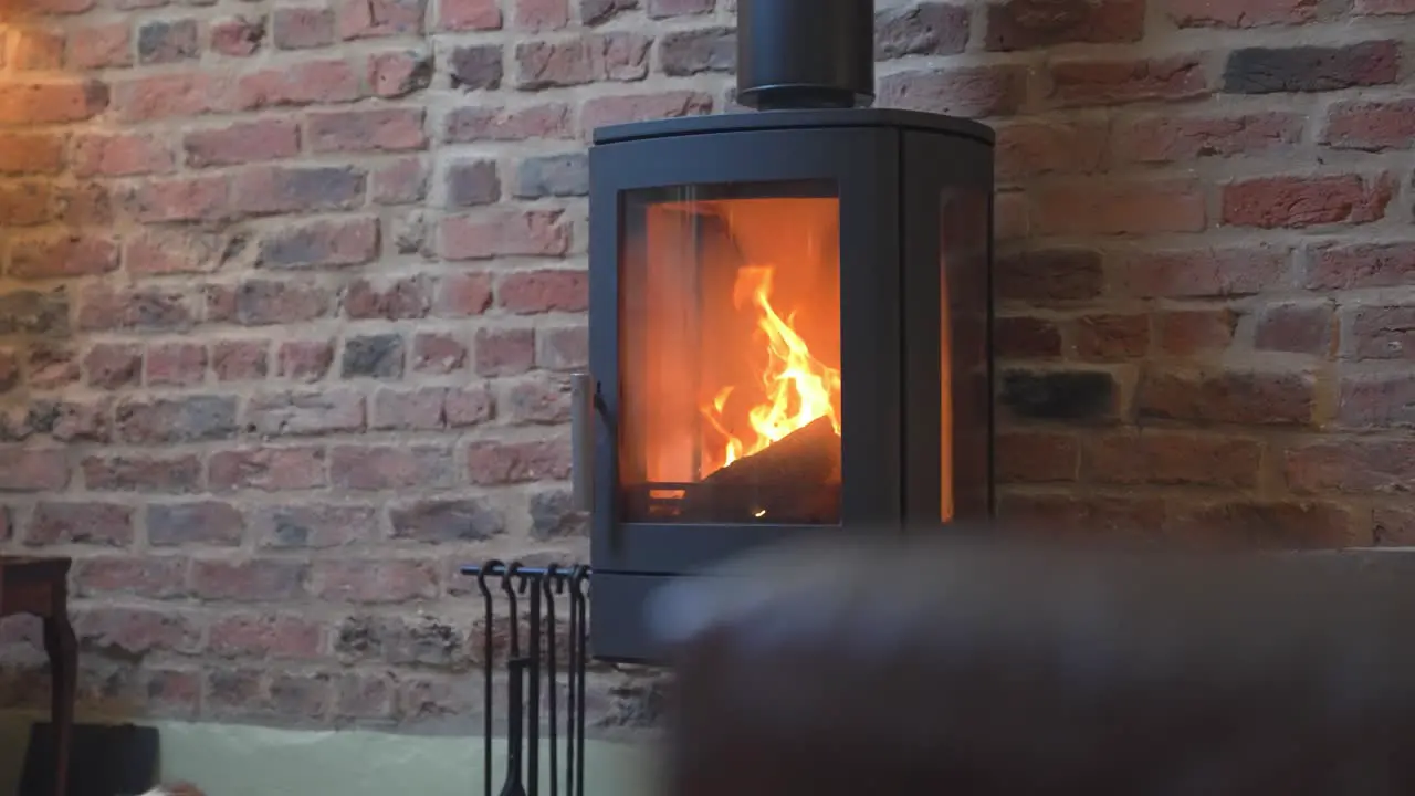 Luxury log burner with tall flu burning very hot with big flames in luxury english farmhouse brick walls