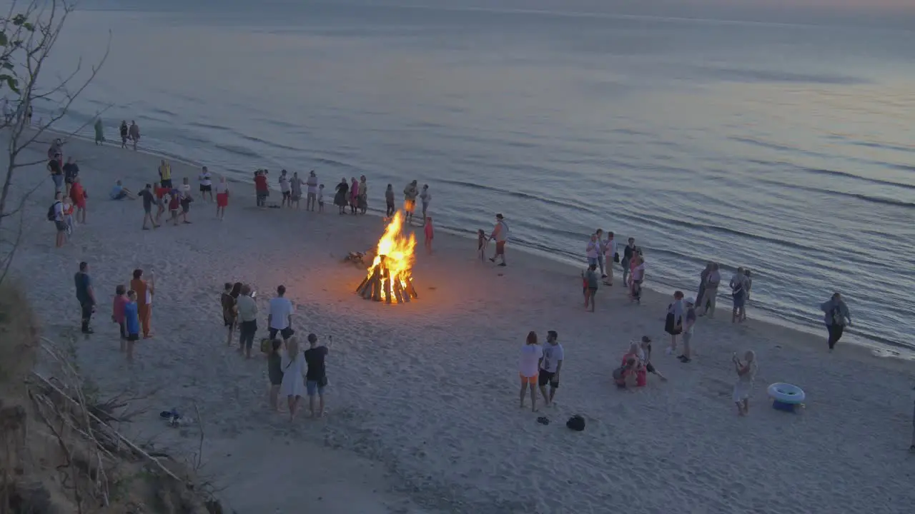 Crowds of People Watch Burning Bonfires on a Latvian Seaside Beach During Sunset