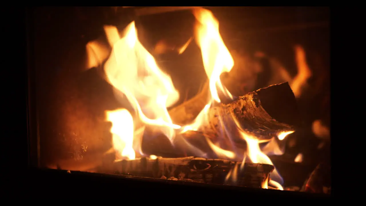 Close-up shot Wood log thrown Into home fireplace glowing flames