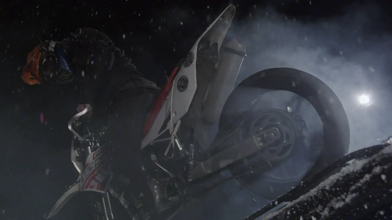 Low angle view of a biker on a cross motorbike burning wheel in slow motion with smoke coming out