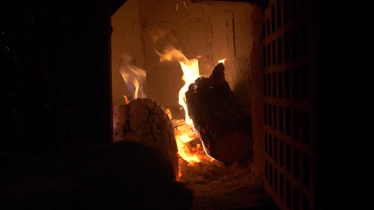 Throwing wood into fire in a tile stove