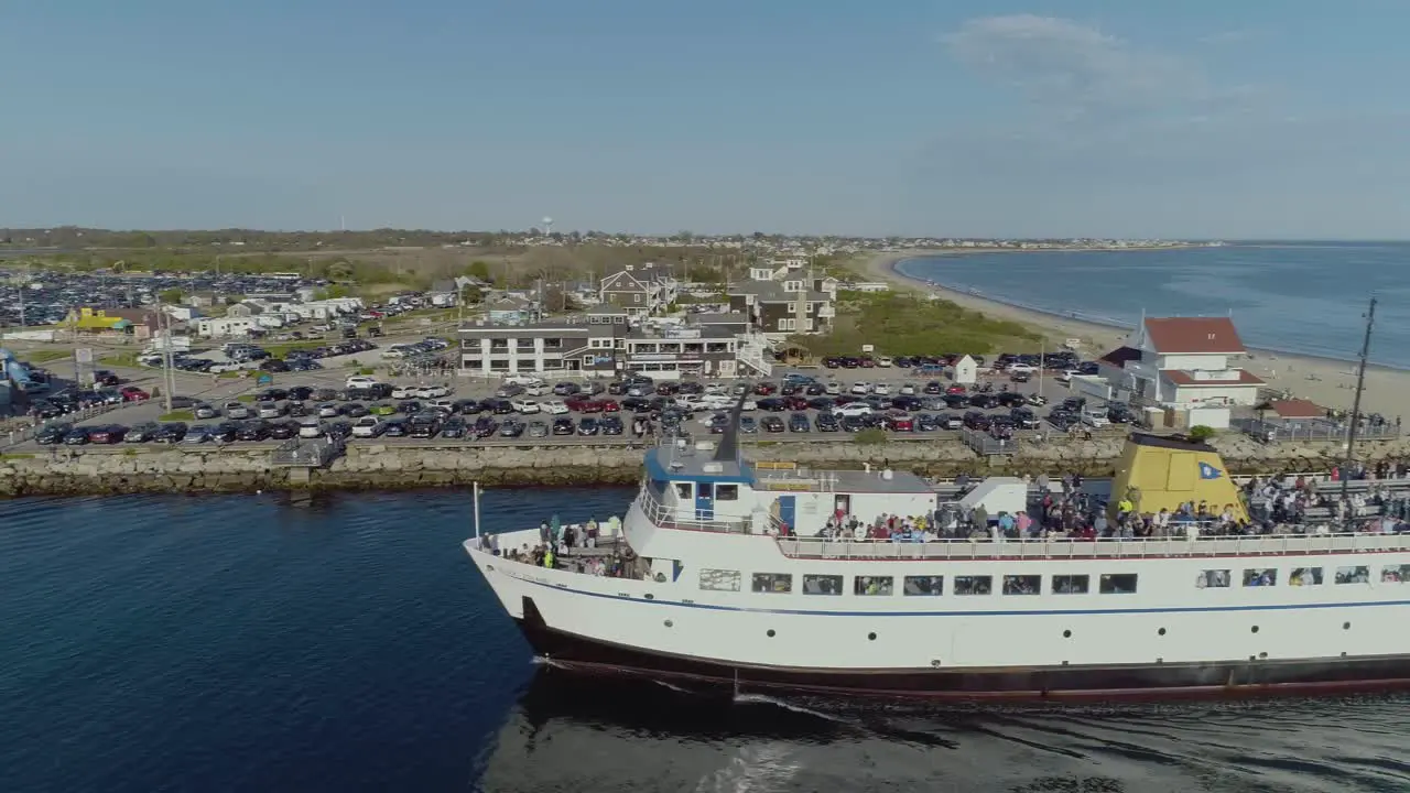 Aerial of a block island ferry boat entering a harbor in rhode island with passengers during the summer time