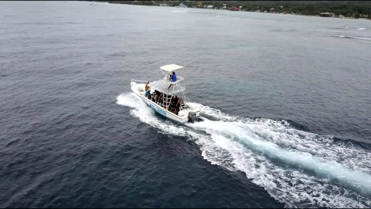 This is stock footage of a dive boat being followed over the oceans of Roaton with a drone