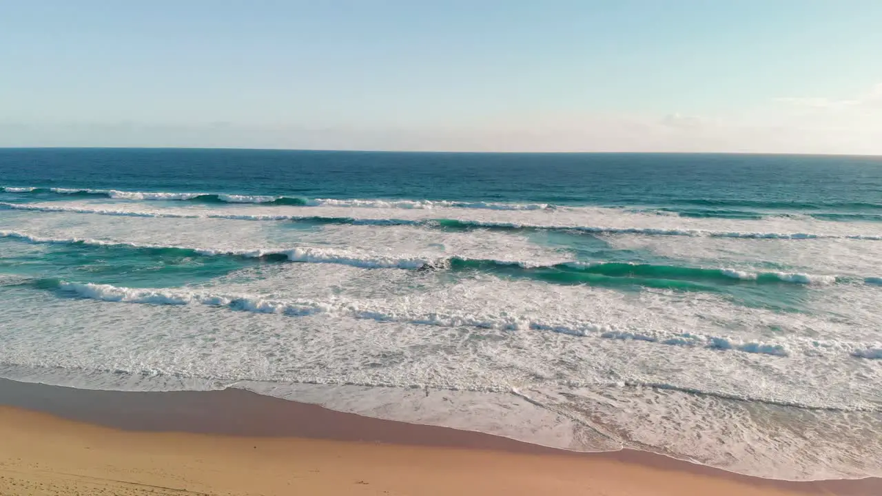 Drone view of beautiful sea waves on the beach Aerial view of ocean shoreline deep blue ocean water and foamy waves