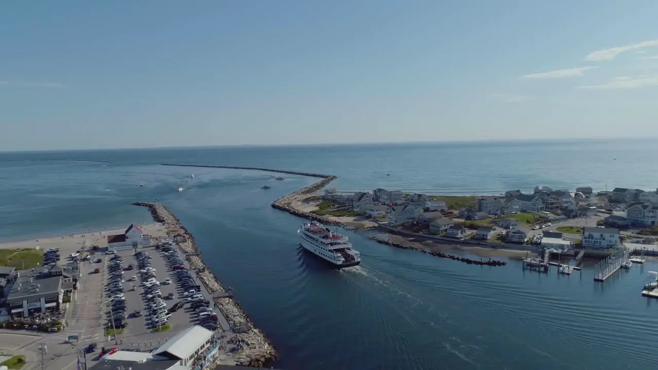 Aerial of a block island ferry boat leaving a harbor in rhode island with passengers during the summer time