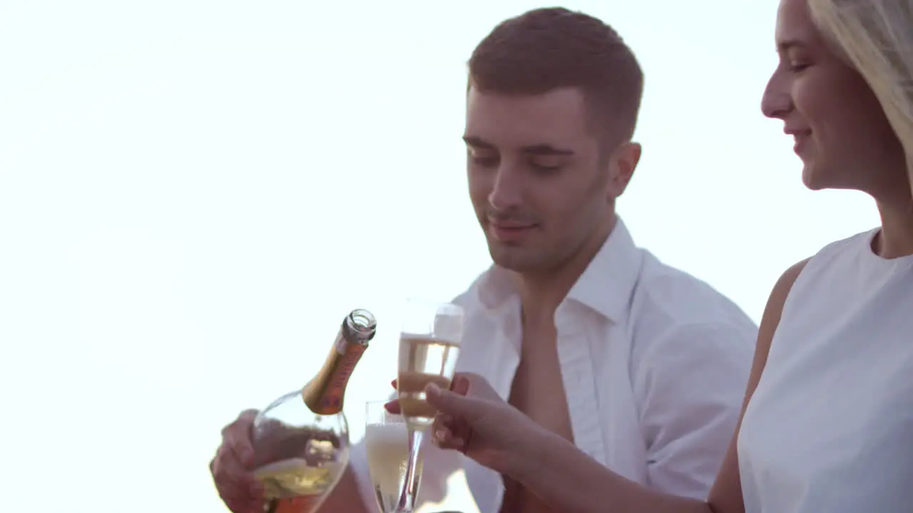 Cute young couple drinking wine at sunset