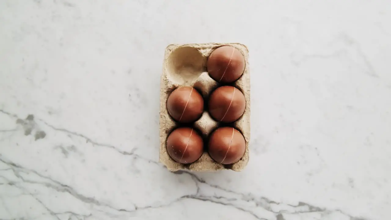 Cinematic rotating shot of golden chocolate Easter eggs on marble surface