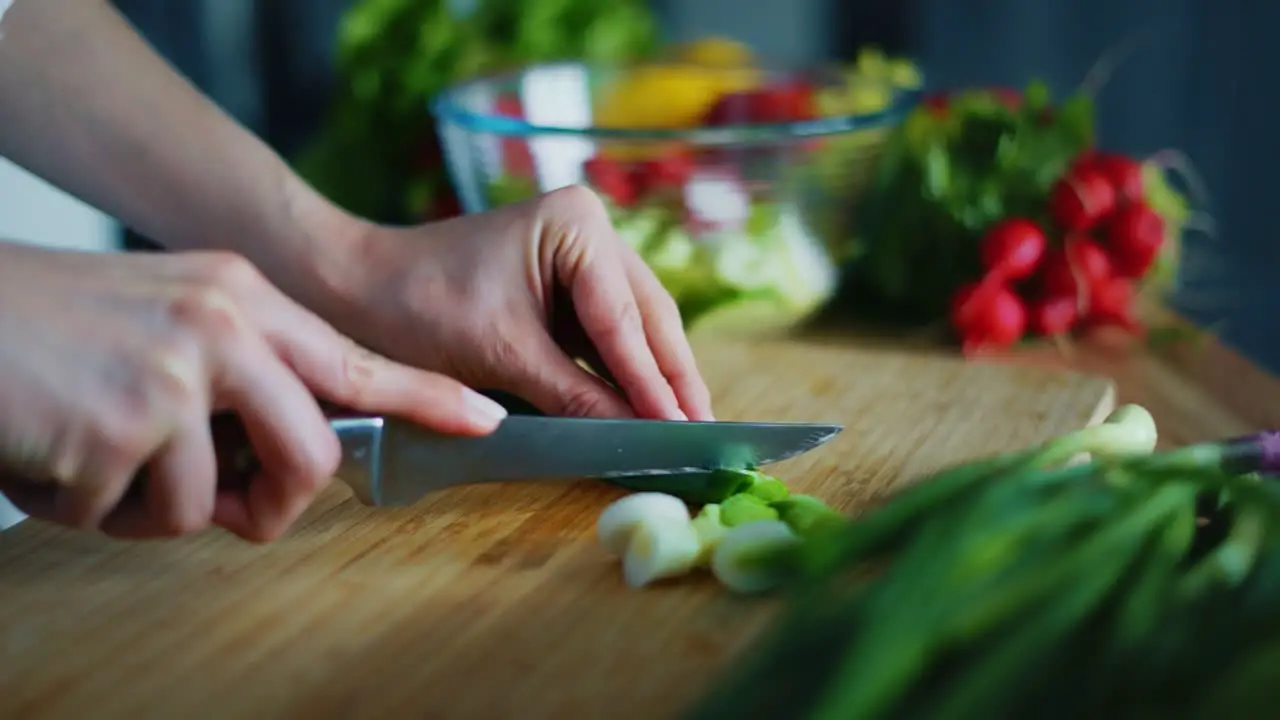 Woman cutting green onion for salad