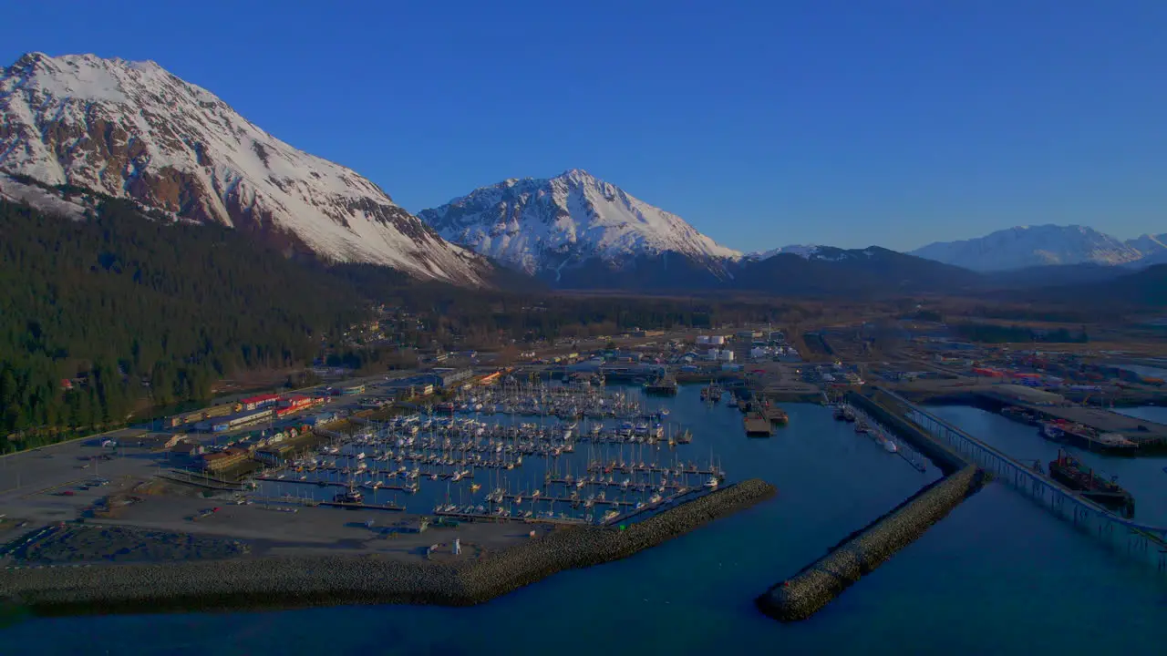 Flying away reveal of Seward Boat Harbor at sunrise tin Seward Alaska