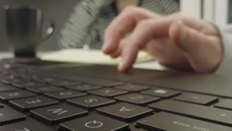 Sliding Extreme Close Up Shot of Pair of Male Hands Drinking Coffee and Using a Laptop