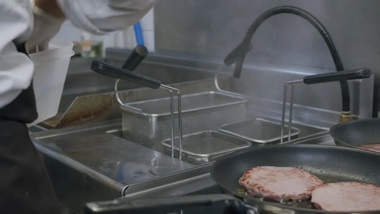 A professional chef is cooking Italian pasta and hamburgers