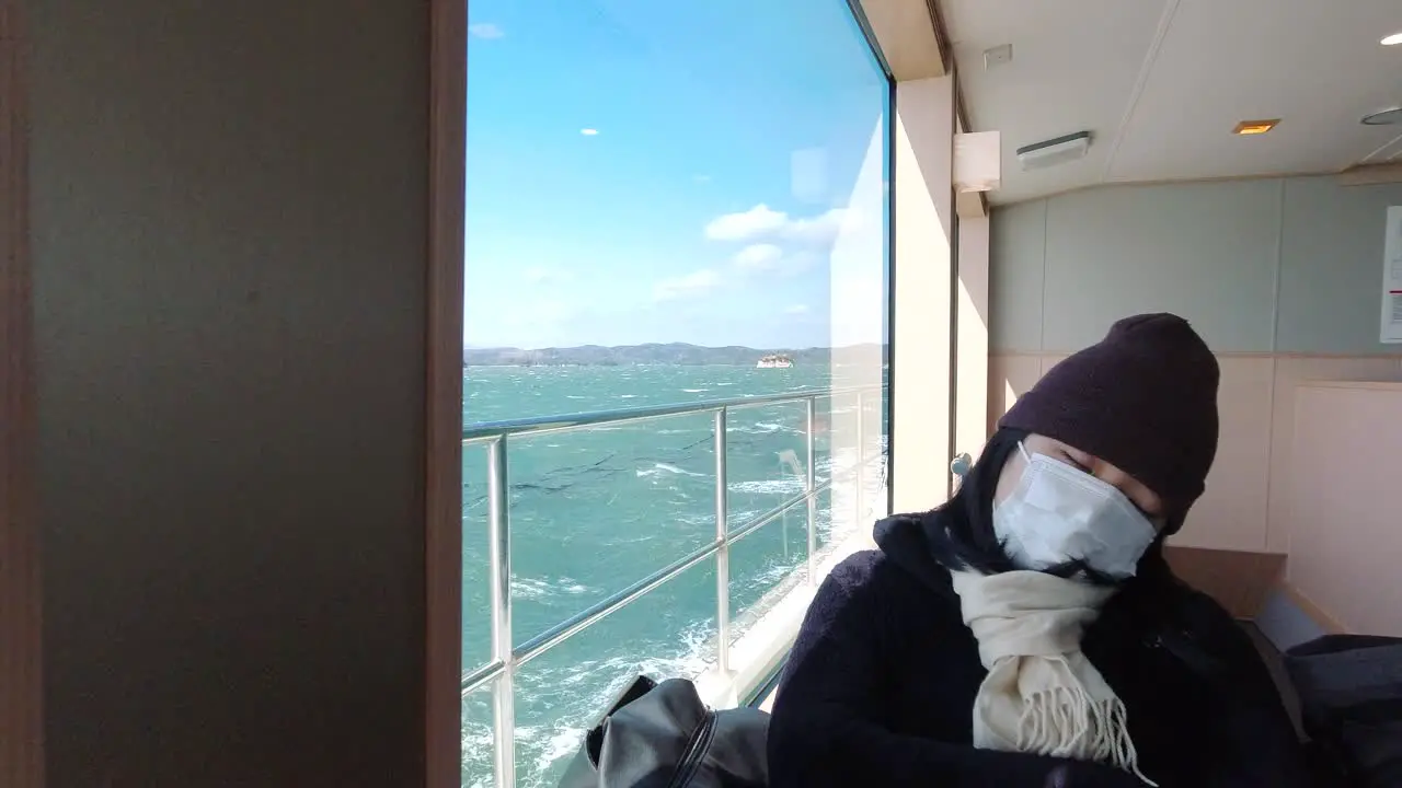 Young tourist sleeping inside moving ship while wearing facemask