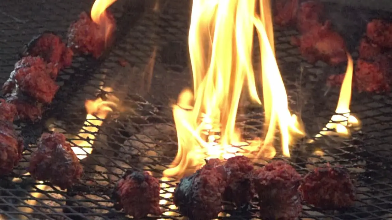 Slow motion fire and sausages on a grill