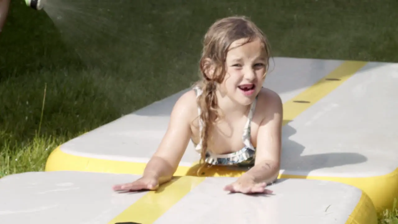 A little girl rides a water slide