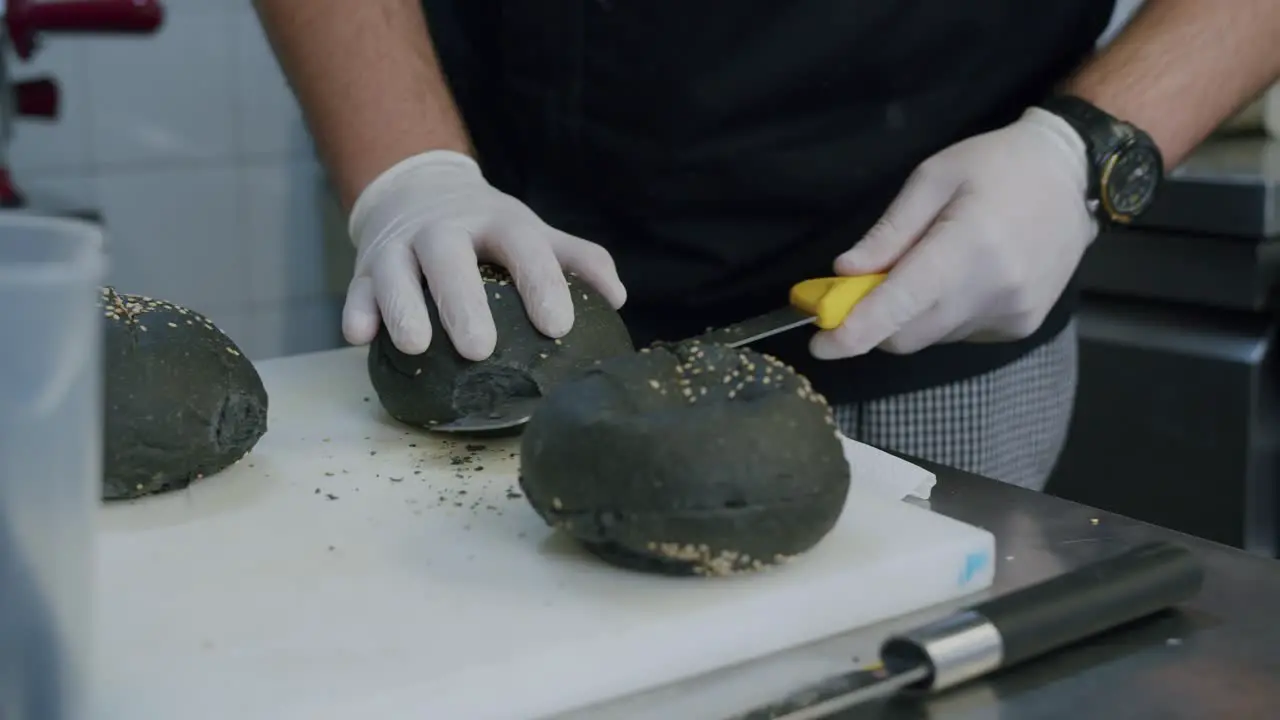 A professional chef is preparing a hamburger in his kitchen 05