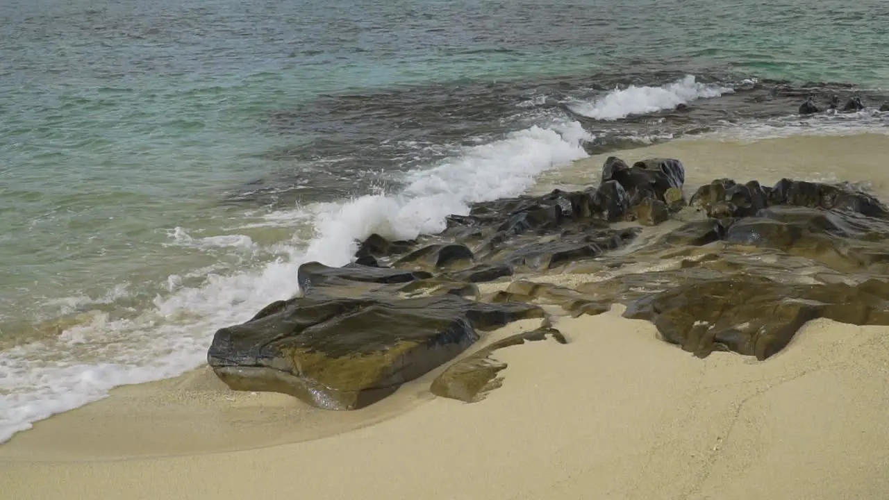 White foam from wave breaking on rocks at Fiji shore slow motion