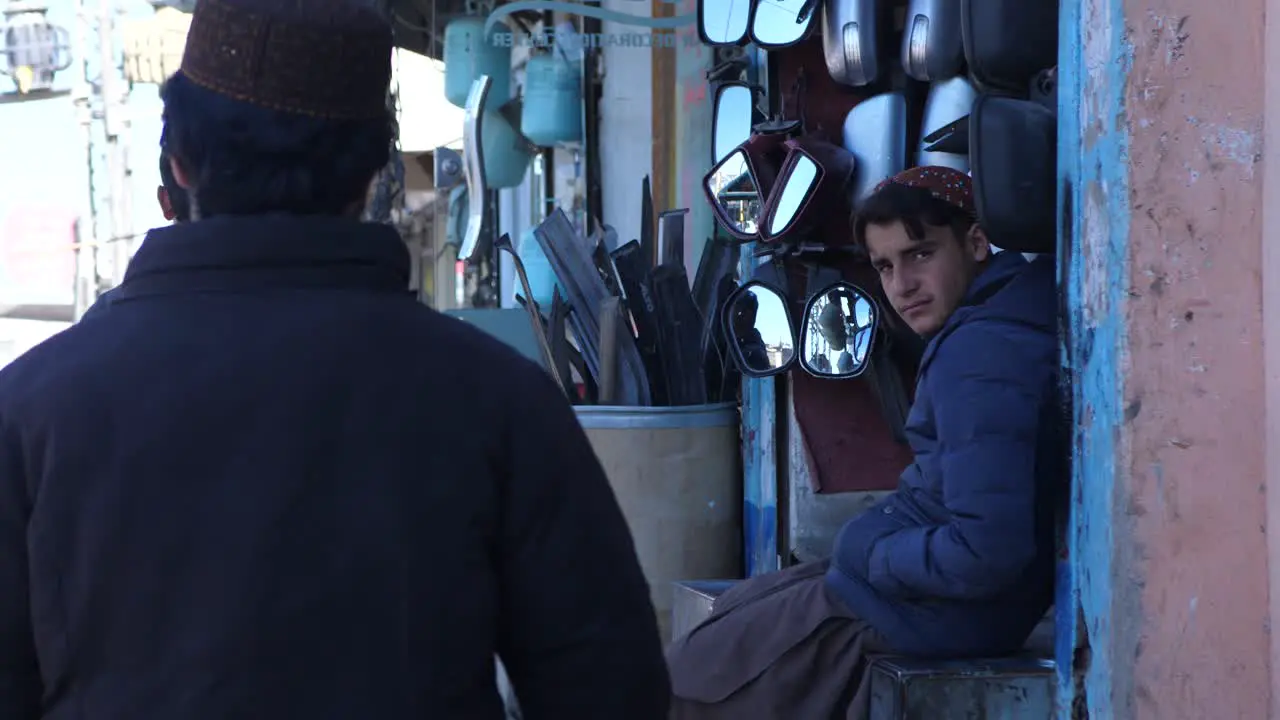 Locals Walking Past Car Parts Shop In Street In Quetta Balochistan