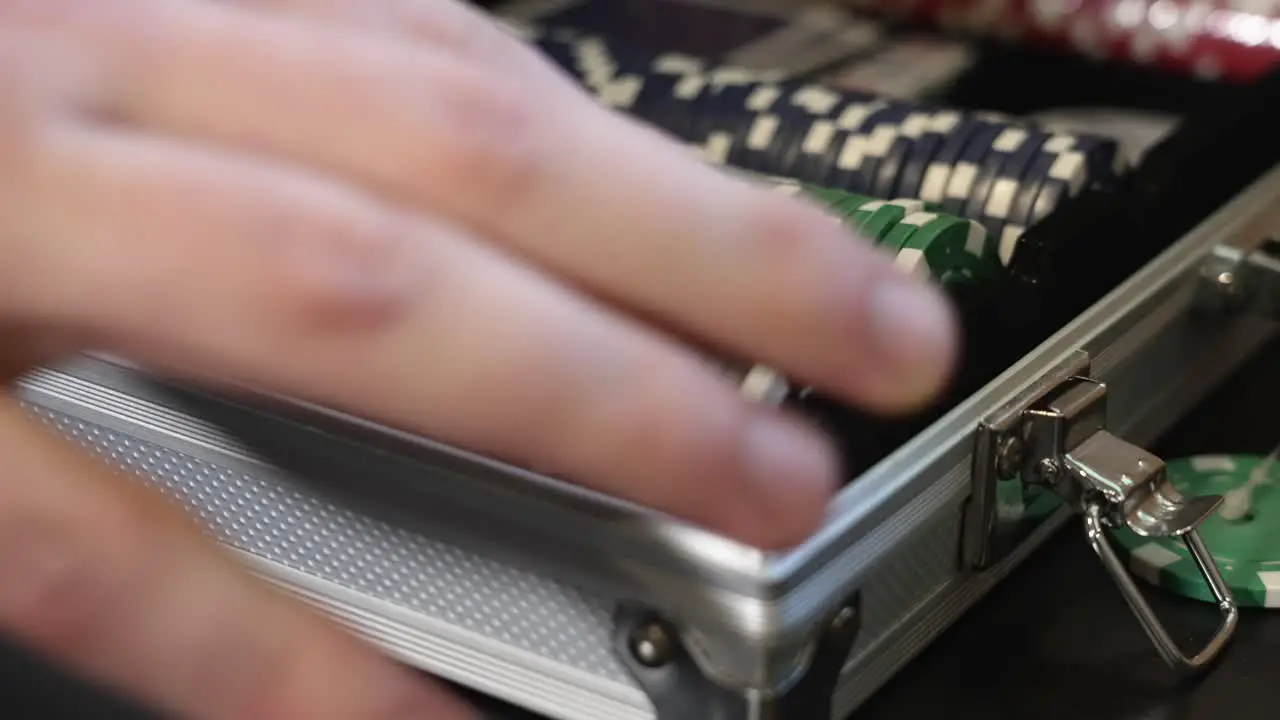 A man places several poker chips or markers back into a case