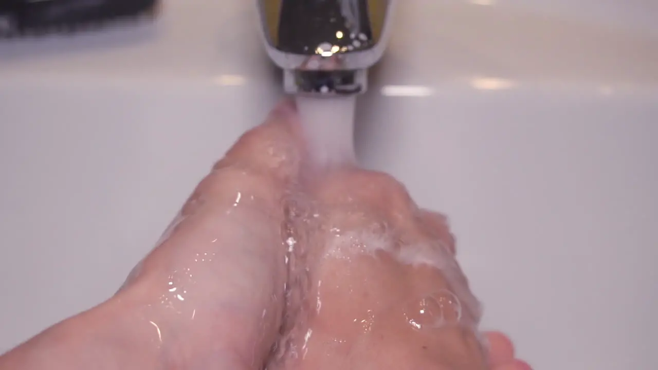 Close up slow motion Man washing male hand with soap and water