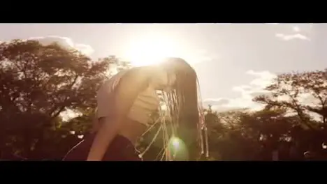 Beautiful woman with dreads styling hair and shaking her head in the son Happy calm attractive girl with long dreads having fun