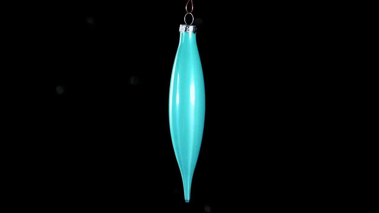 single blue turquoise Christmas cone ornament with black background close up