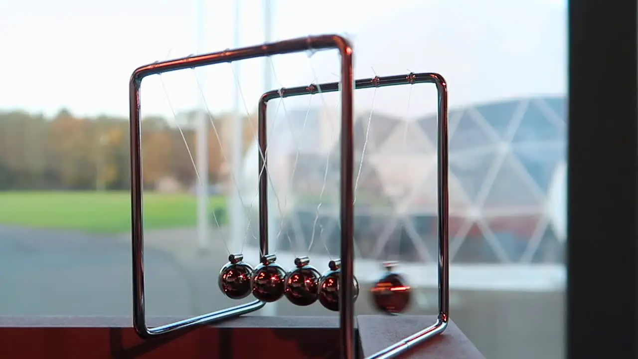 newton's cradle with spheres in motion and colorful background in 50fps