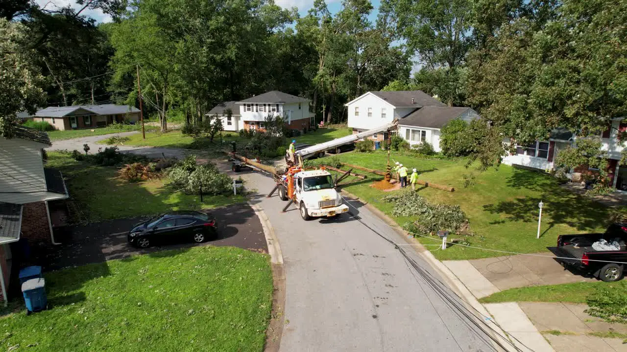 replaing utility pole after storm drone cinematic slow slide up and right