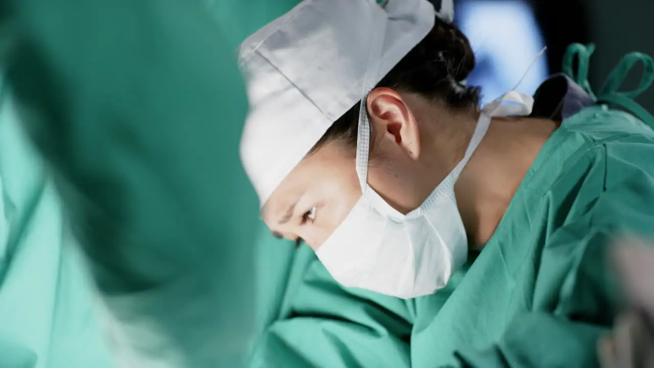 Asian female surgeon operating on patient in operating theatre at hospital slow motion