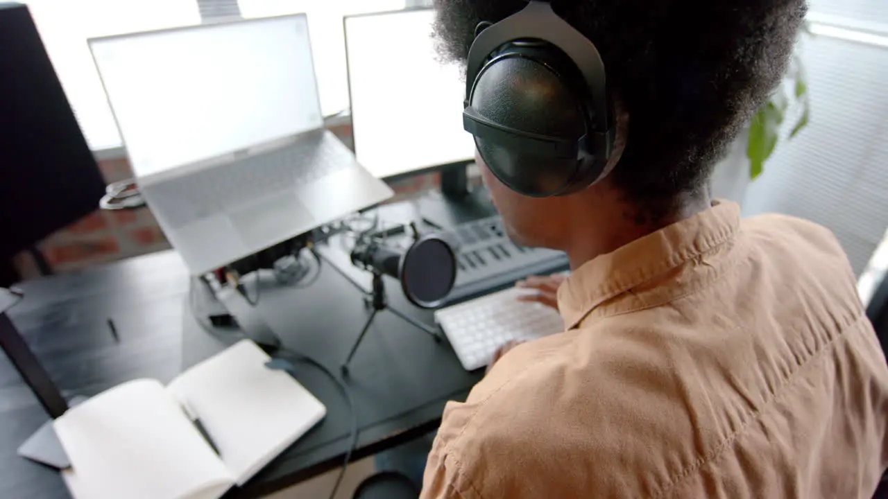 African american man in headphones podcasting at home slow motion