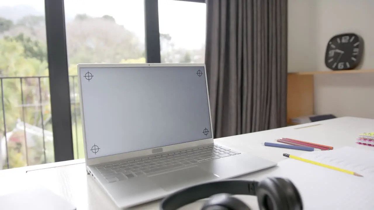 Close up of laptop with copy space on screen and headphones on desk slow motion