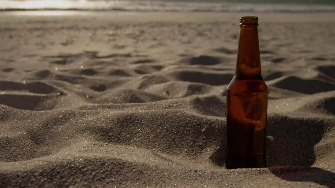 Beer bottle on sand at beach 4k