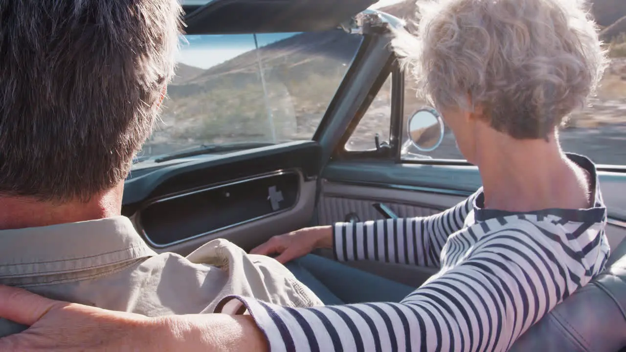 Senior couple in open car woman in passenger seat close up