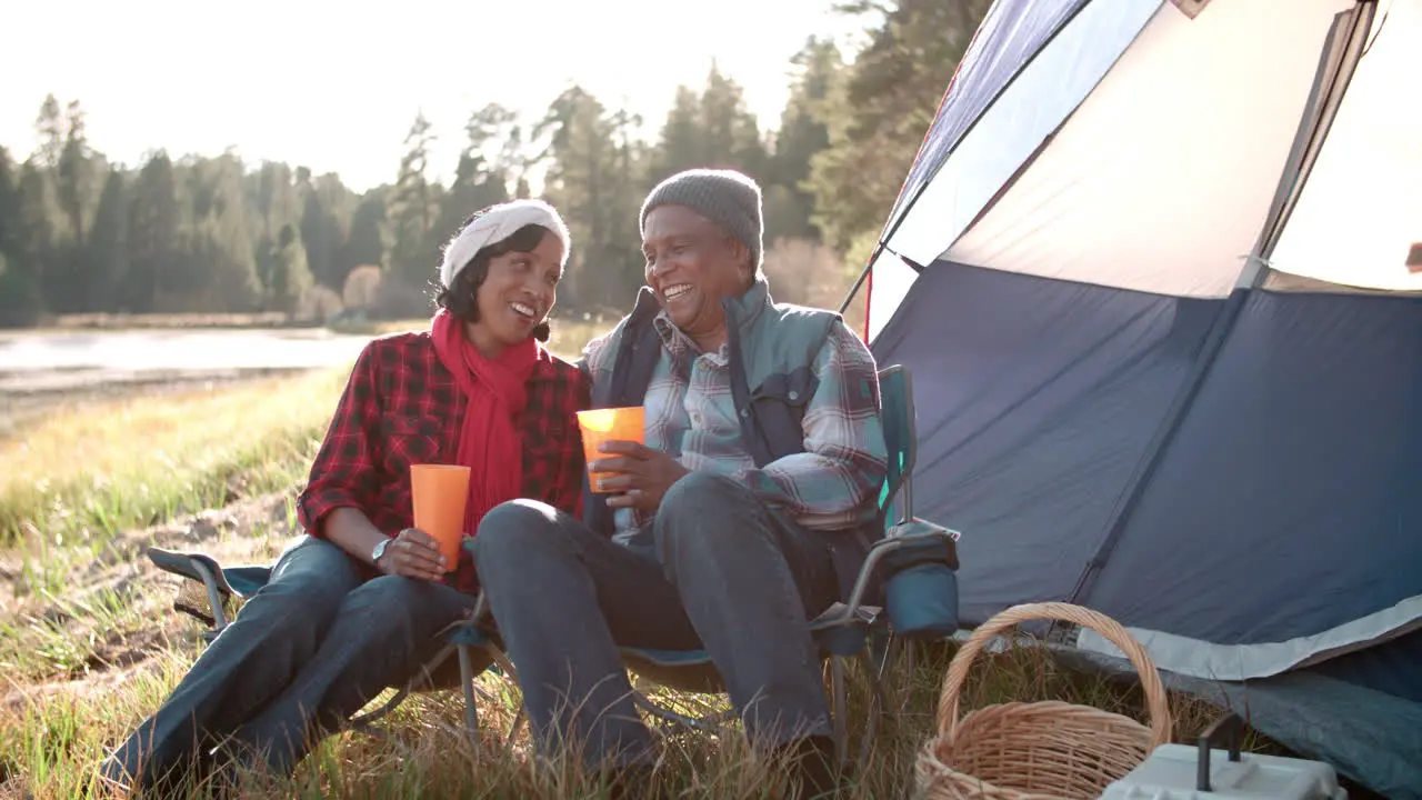 Senior black couple on a camping trip relax outside tent