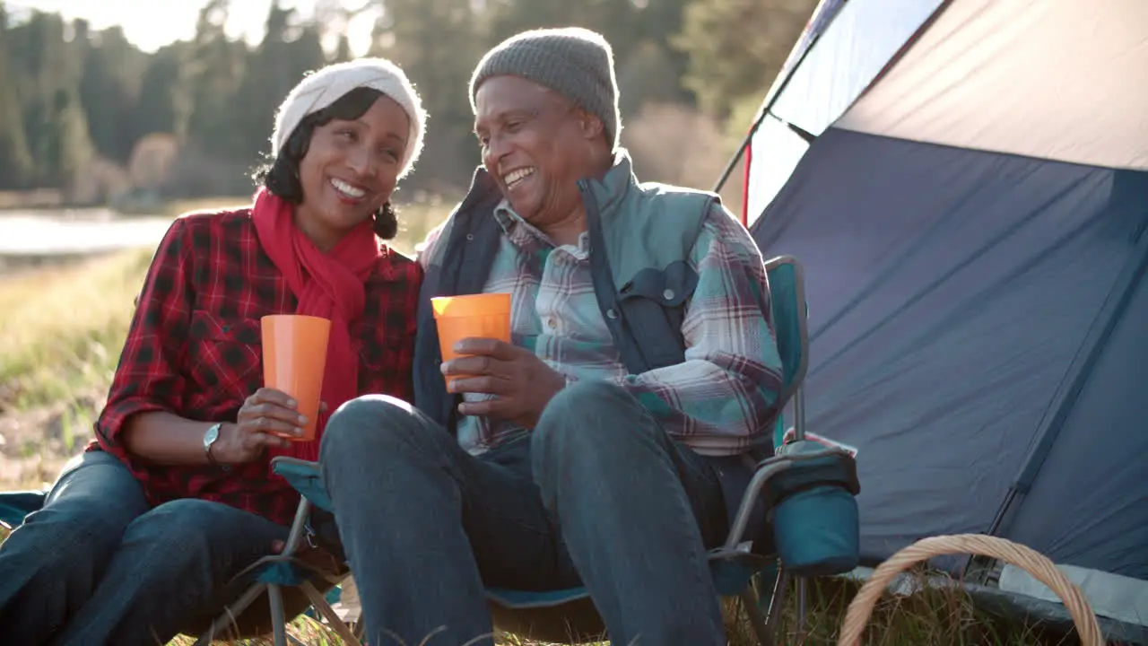 Senior black couple on camping trip outside tent close up