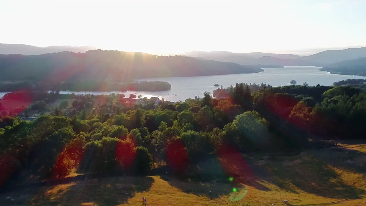 Drone shot showing sheep and people walking in the countryside beside Lake Windermere Lake District UK