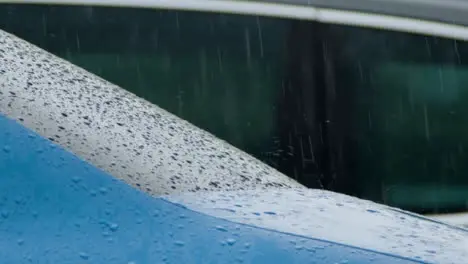 Panning Shot of Heavy Rain Falling On Blue Car Window and Body