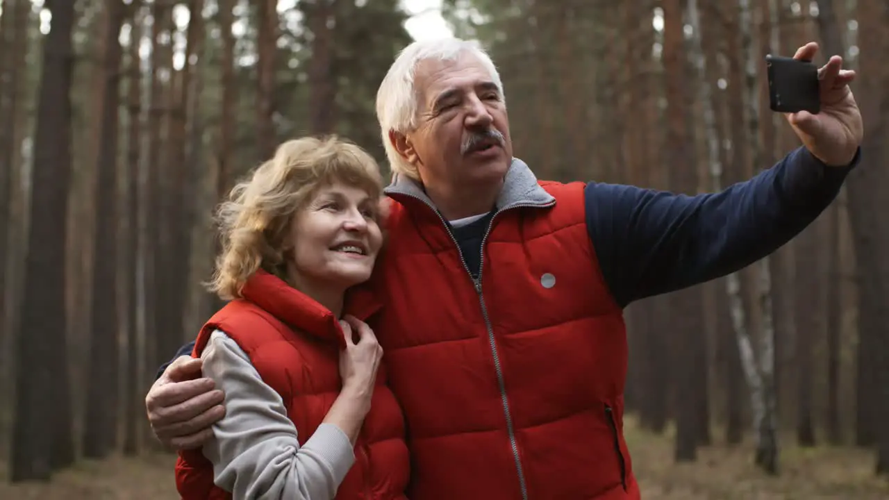 Happy Senior Couple Making Selfie During Their Winter Sports Training In The Forest