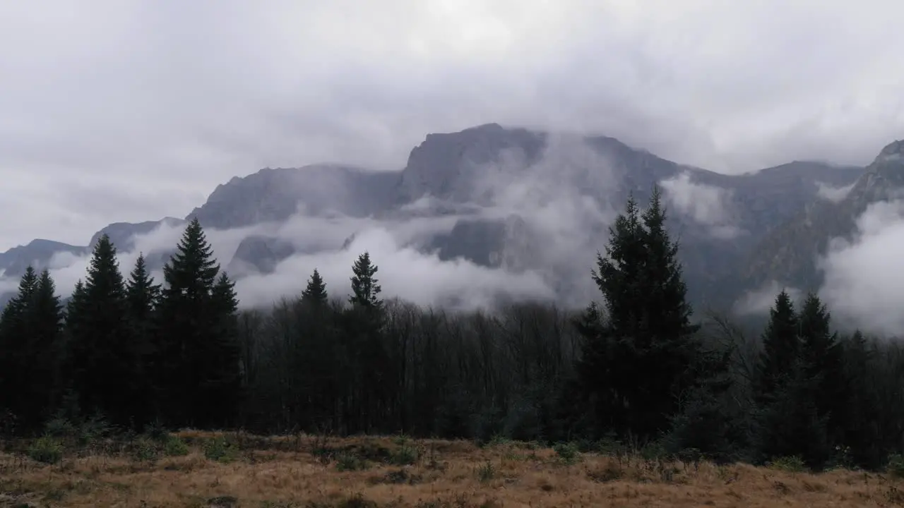 Left to right panning shot of a mountain landscape with mist