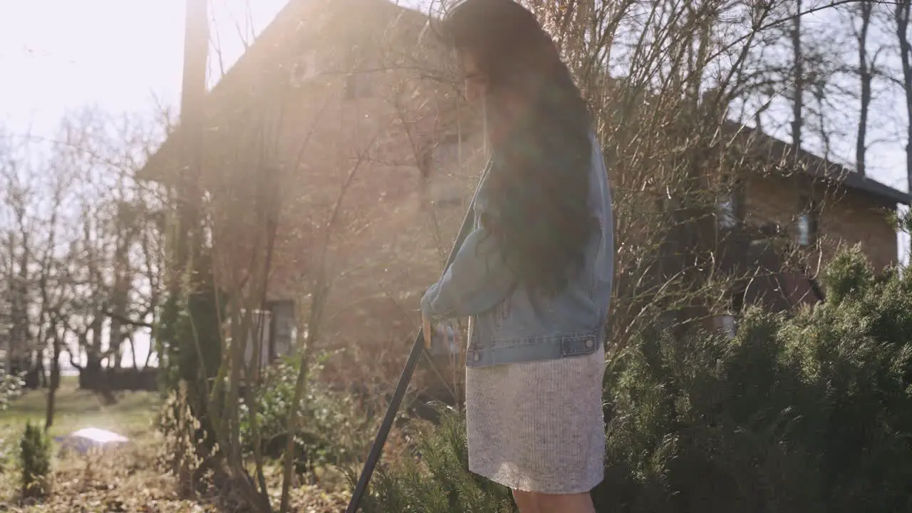 Caucasian woman removing weeds with a rake in the countryside